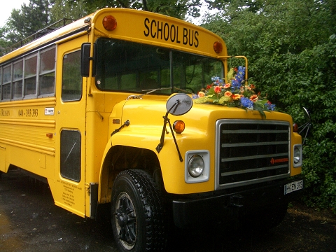 Schulbus mit Blumenbouquet auf Kühlerhaube für Hochzeiten