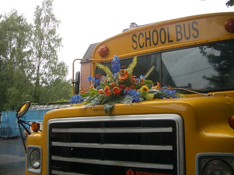 Schulbus mit Blumenbouquet auf Kühlerhaube für Hochzeiten