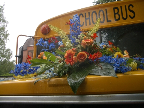 Schulbus mit Blumenbouquet auf Kühlerhaube für Hochzeiten