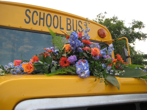 Schulbus mit Blumenbouquet auf Kühlerhaube für Hochzeiten